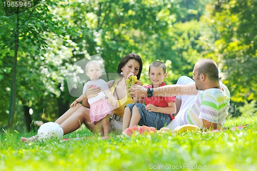 Image of happy young couple with their children have fun at park
