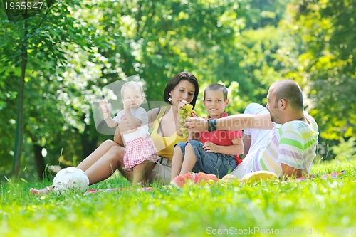Image of happy young couple with their children have fun at park