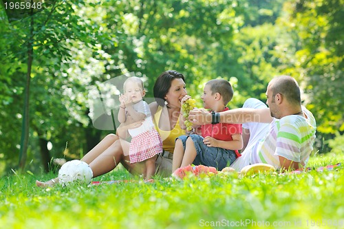 Image of happy young couple with their children have fun at park