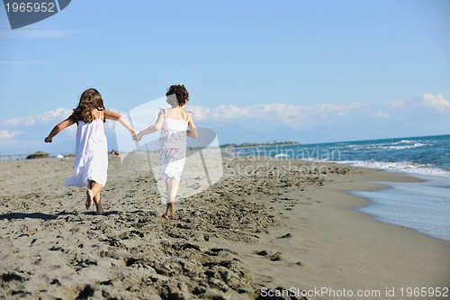Image of cute little girls running on beach