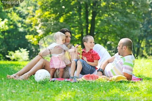 Image of happy young couple with their children have fun at park