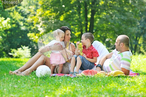 Image of happy young couple with their children have fun at park