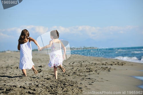 Image of cute little girls running on beach