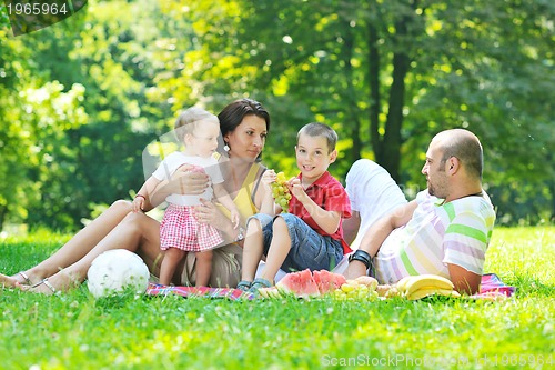 Image of happy young couple with their children have fun at park