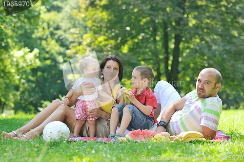 Image of happy young couple with their children have fun at park