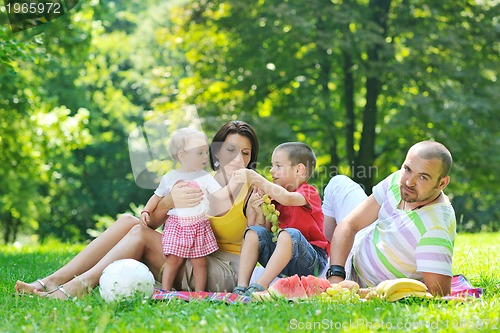Image of happy young couple with their children have fun at park