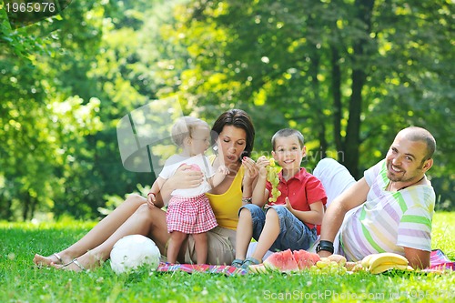 Image of happy young couple with their children have fun at park