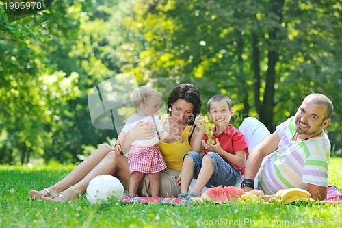 Image of happy young couple with their children have fun at park