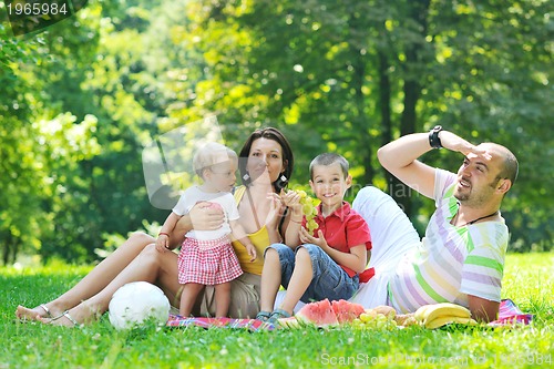 Image of happy young couple with their children have fun at park