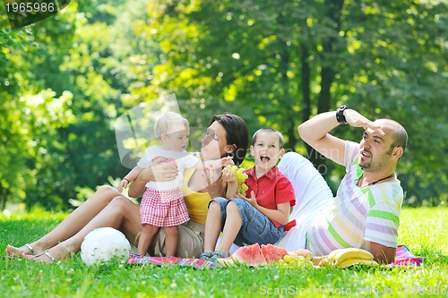 Image of happy young couple with their children have fun at park