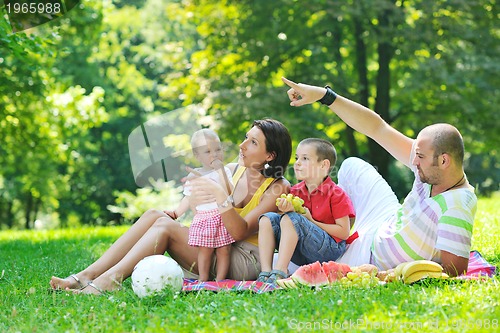 Image of happy young couple with their children have fun at park