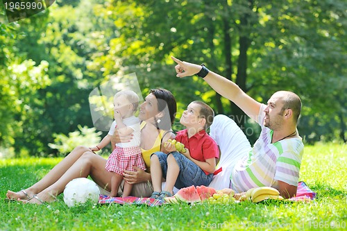 Image of happy young couple with their children have fun at park