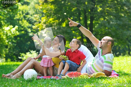 Image of happy young couple with their children have fun at park