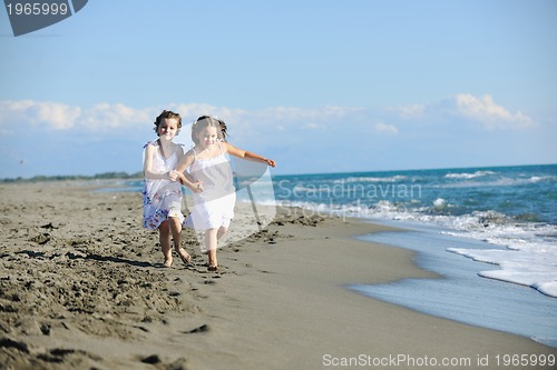 Image of cute little girls running on beach