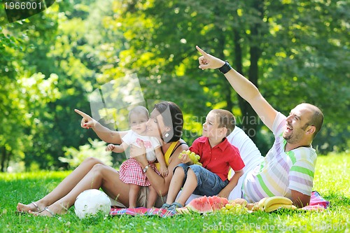 Image of happy young couple with their children have fun at park