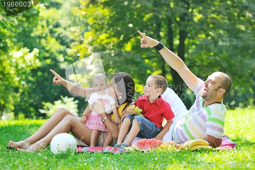 Image of happy young couple with their children have fun at park