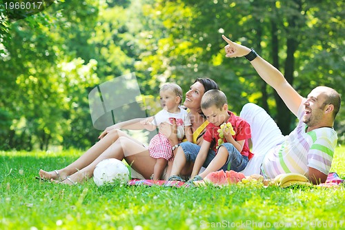 Image of happy young couple with their children have fun at park