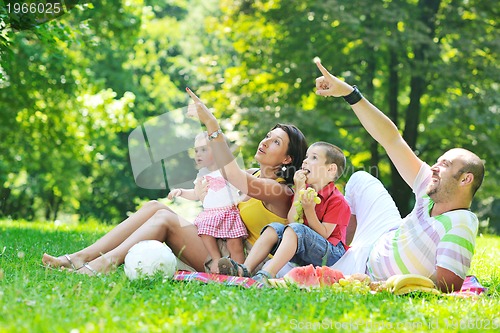 Image of happy young couple with their children have fun at park
