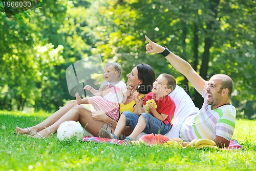 Image of happy young couple with their children have fun at park