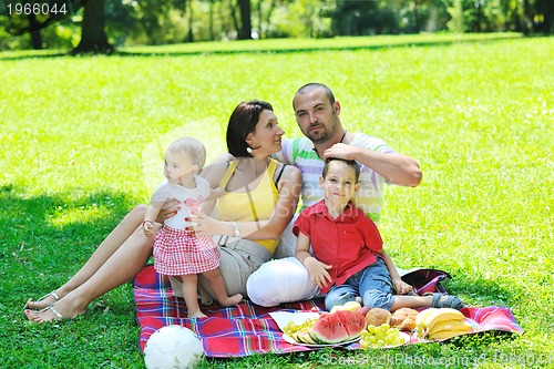 Image of happy young couple with their children have fun at park