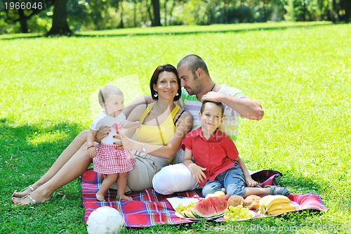 Image of happy young couple with their children have fun at park