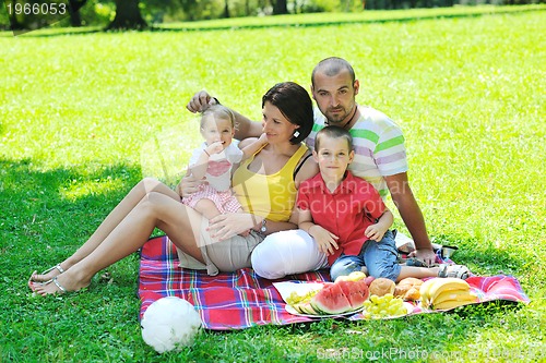 Image of happy young couple with their children have fun at park