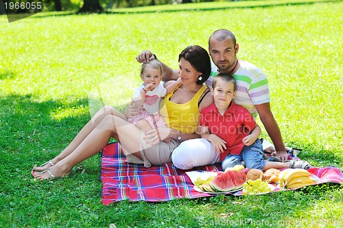 Image of happy young couple with their children have fun at park
