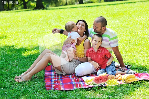 Image of happy young couple with their children have fun at park