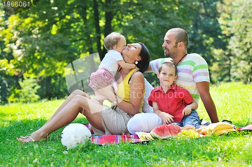 Image of happy young couple with their children have fun at park