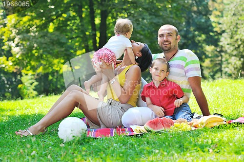 Image of happy young couple with their children have fun at park