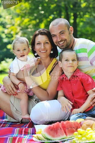 Image of happy young couple with their children have fun at park