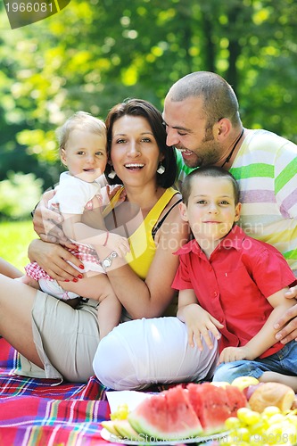 Image of happy young couple with their children have fun at park