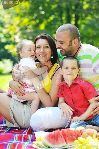 Image of happy young couple with their children have fun at park