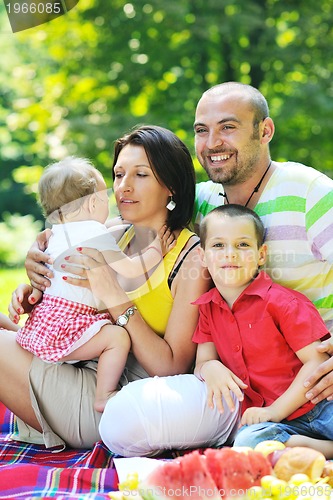 Image of happy young couple with their children have fun at park