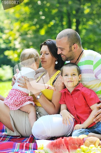 Image of happy young couple with their children have fun at park