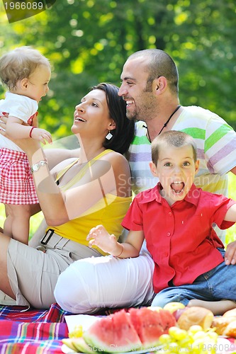 Image of happy young couple with their children have fun at park