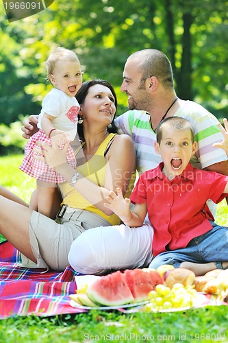 Image of happy young couple with their children have fun at park