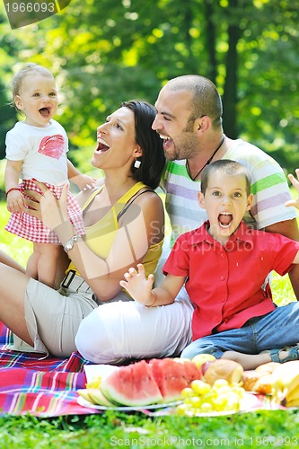 Image of happy young couple with their children have fun at park