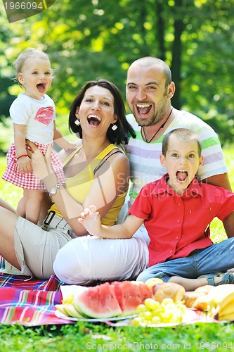 Image of happy young couple with their children have fun at park