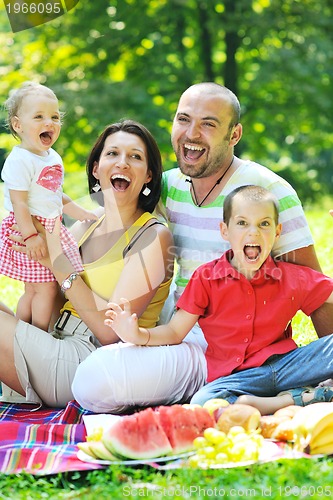 Image of happy young couple with their children have fun at park