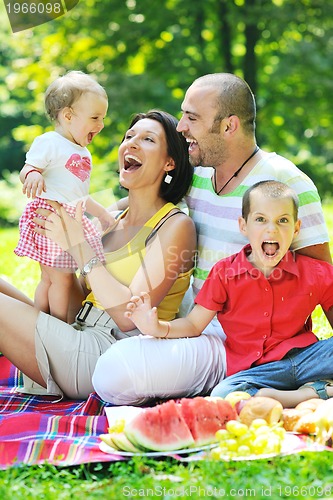 Image of happy young couple with their children have fun at park