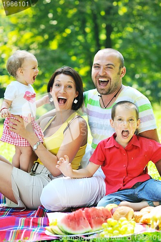 Image of happy young couple with their children have fun at park