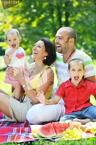 Image of happy young couple with their children have fun at park
