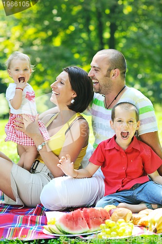 Image of happy young couple with their children have fun at park