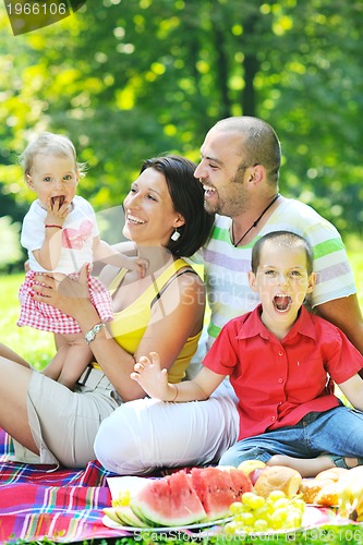 Image of happy young couple with their children have fun at park