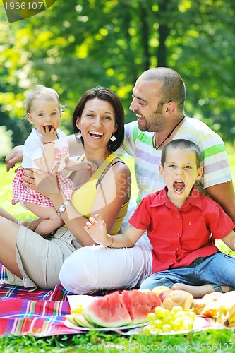 Image of happy young couple with their children have fun at park