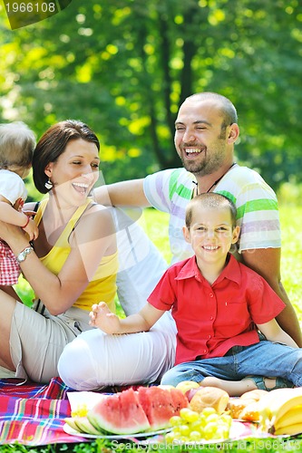 Image of happy young couple with their children have fun at park