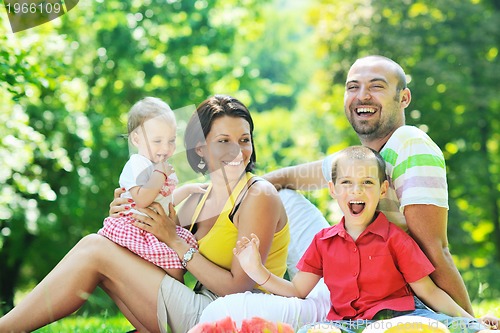 Image of happy young couple with their children have fun at park