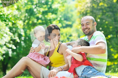 Image of happy young couple with their children have fun at park