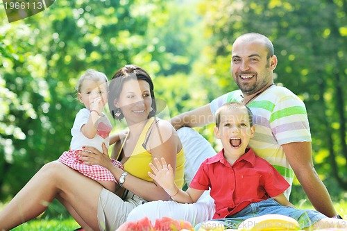 Image of happy young couple with their children have fun at park